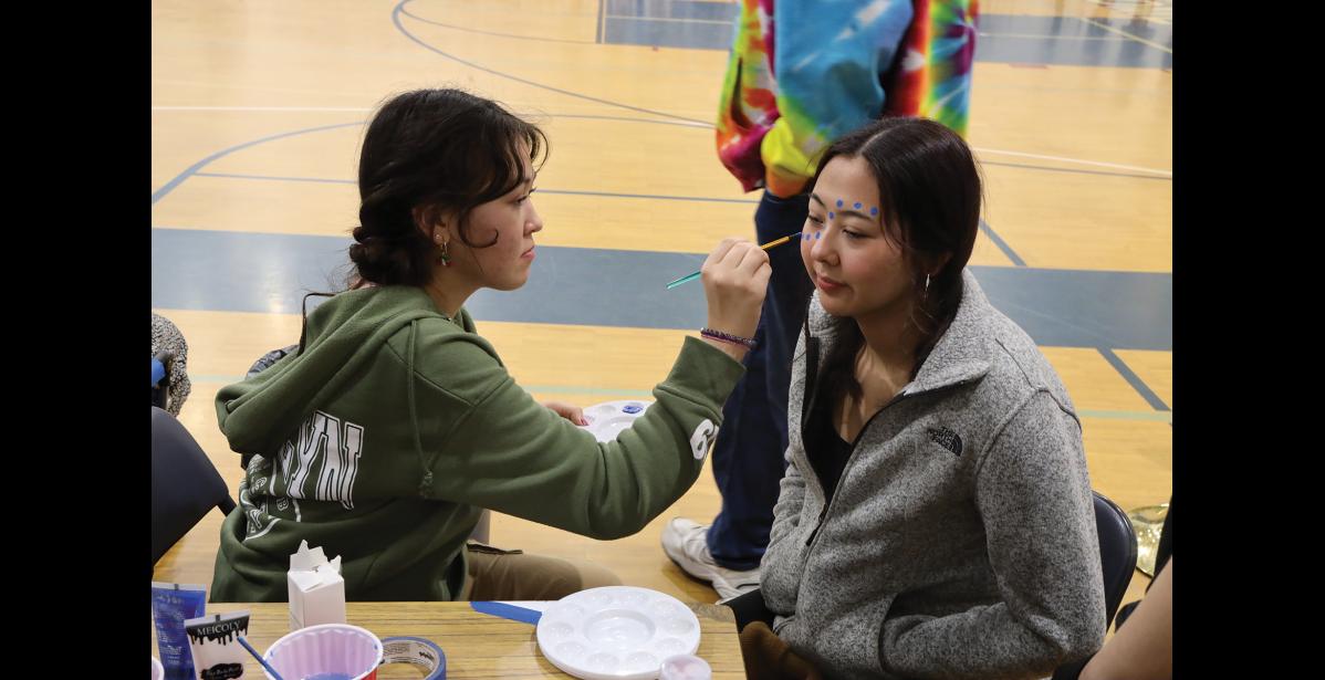 Photo by Anna Lionas Angela Moss paints Melody Olanna’s face in Nanook colors.