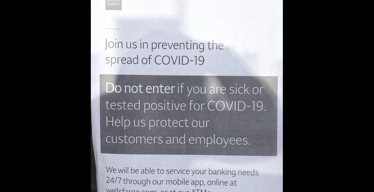 Photo by Nils Hahn SIGNS OF THE TIME— Businesses post signs at their doors warning people to stay out if they are sick