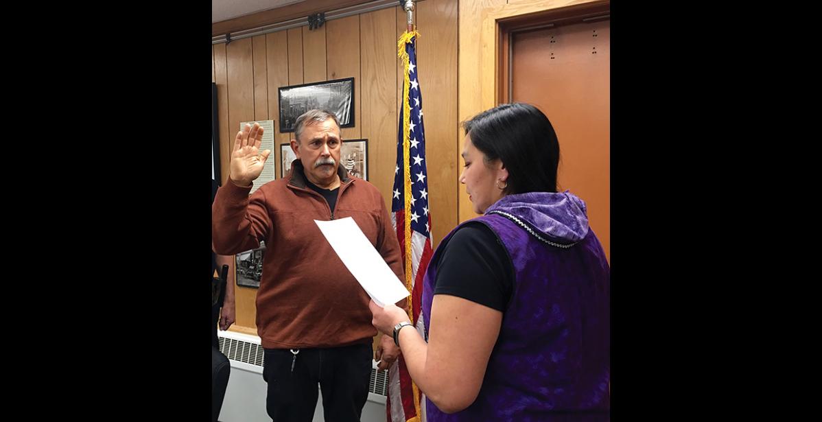 Photo by Sandra Medearis NVESTIGATOR— Detective Michael Heintzelman has taken a temporary full-time job with Nome Police Dept. as a full-time investigator to help clear a backlog of cases. Here, Christine Piscoya, deputy city clerk, administers Heintzelman’s oath of office.