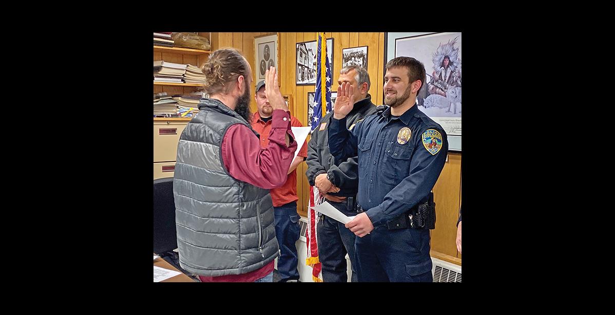 Photo by Sandra Medearis HE SOLEMNLY PROMISES—Austin Martino, newly hired Nome police officer takes his oath of office administered by Bryant Hammond, city clerk. Martino comes from New York.