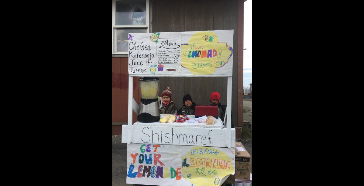 Photo by Tyler Ivanoff LEMONADE DAY SHISHMAREF— Katesonja, Tyrese and Jace Ivanoff set up their lemonade stand outside of the community hall in Shishmaref during last Saturday’s Lemonade Day. Kids in Nome and the region practiced their business skills as they sold ice cold lemonade, baked goods and other delicacies to folks in their communities