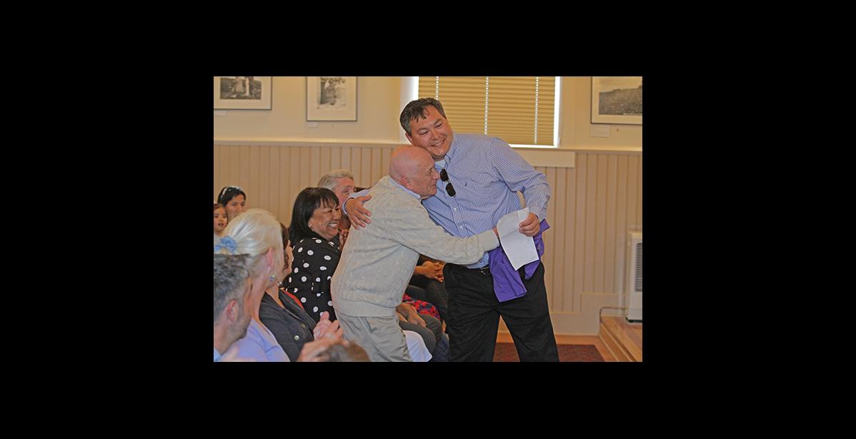 Photo by Diana Haecker Richard Beneville gives Jake Kenick a hug during a celebration of Beneville's contributions to Nome last year at Old St. Joe's.