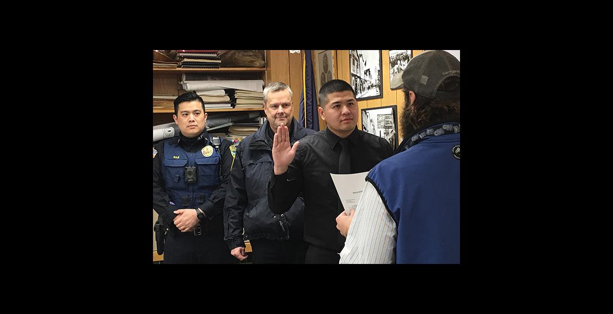 Photo by Sandra Medearis New NPD officer Vingent Nguyen is sworn in by City Clerk Bryant Hammond as NPD Chief Bob Estes and officer Alex Le look on.