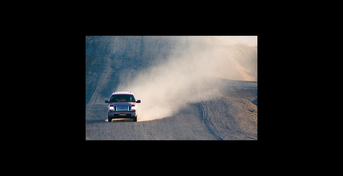 Photo by James Mason RAISING DUST – A pickup truck on Greg Kruschek Avenue raises a cloud of dust. With no snow yet Nome is a dusty place.