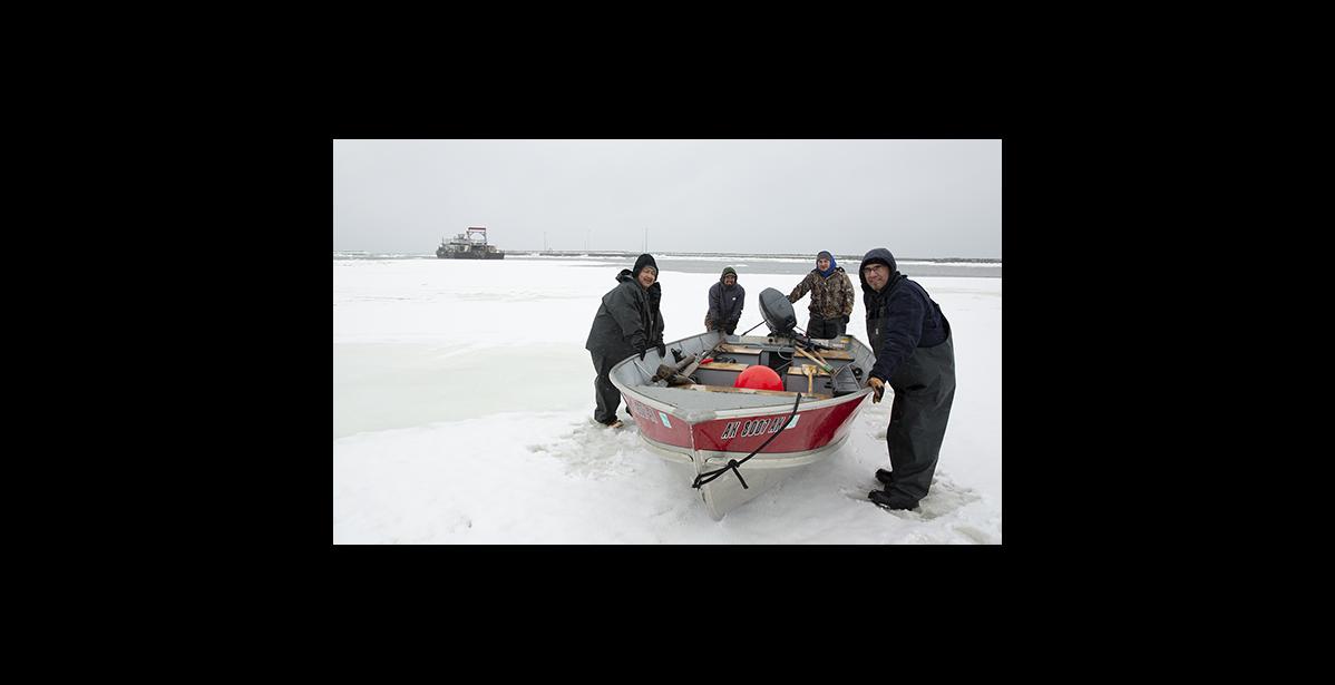 Photo by James Mason RETURN — Back at the port following a hunt in difficult weather, the crew pushes the boat up the ice to the trailer. They are Ben Apassingok, Lonnie Booshu, Joe Cross III and David Booshu.