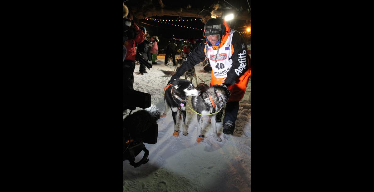 Photo by Diana Haecker Thomas Waerner thanks his lead dogs Bark and K2 for the ride.