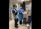 Photo by Mark Hayward ON THE FRONT LINES— Dr. Cristina Peñon, right, consults with CHA-II Camille Katcheak, left, before donning full personal protective equipment to interview a positive COVID-19 patient in Stebbins.