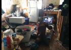 NOWHERE TO GO— Two children sit on the floor of their living room in 2018. Two people sleep on the living room floor of this one-bedroom house in Savoonga, three sleep in the bedroom, and four sleep in the former kitchen.