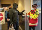 Photo by James Mason ARRIVAL IN NOME – Nome Emergency Services Technician Rose Reale checks an arrival’s travel permit in the Alaska Airlines terminal in Nome on Thursday