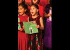 Photo by James Mason SING IT! – Second graders Hannah Harrelson and Violet Fagundes add their voices to Christmas Card during last week’s Nome Elementary Holiday Program.